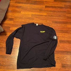 deep yellow corner logo with arm logo in white long sleeve shirt